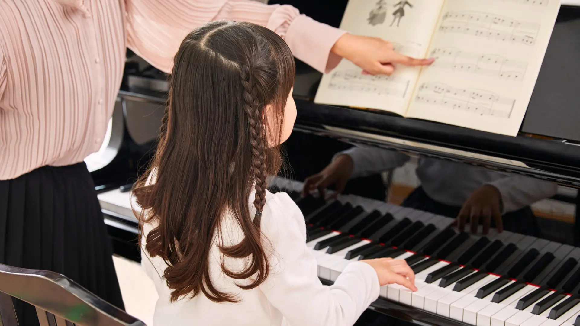 A young piano student practising with her teacher at VP School of Music